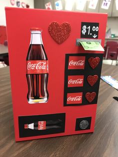 a coca - cola vending machine with hearts on the front and sides, sitting on a table