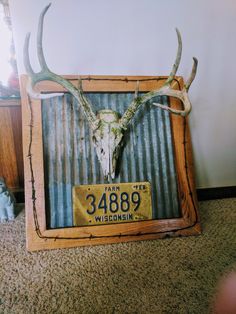 a deer's head mounted on the side of a wall with a license plate