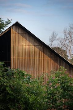 an old barn is surrounded by trees and bushes