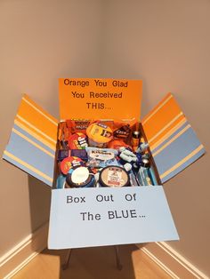 an orange box filled with items sitting on top of a wooden floor