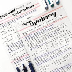 two notebooks with writing on them next to pens and paper that have chemical symbols