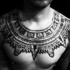 a man with tattoos on his chest and chest