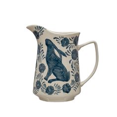 a blue and white pitcher with a dog on it