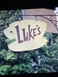 a sign hanging from the side of a building that says luke's on it