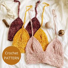 three crocheted bras laying on top of a bed next to each other