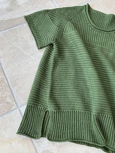 a green sweater laying on the floor