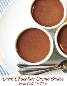 three cups of chocolate creme on a plate with spoons next to it and the words, dark chocolate creme brule