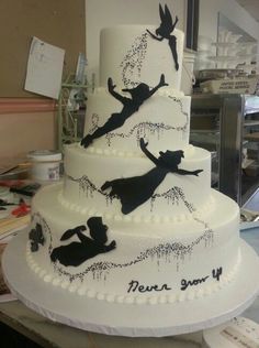 a large white cake with black silhouettes on it