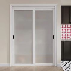 an empty room with sliding glass doors in the middle and black cabinets on either side