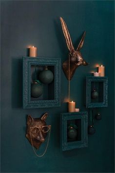 the wall is decorated with candles, ornaments and an animal's head on it