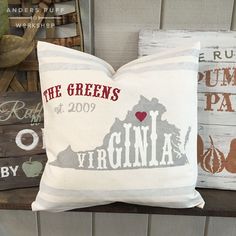 a white pillow with the state of virginia on it sitting next to other decorative items