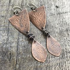 Rustic Drop Earrings With Ear Wire, Rustic Handmade Teardrop Earrings, Copper Oxidized Finish Drop Earrings, Metal Dangle Jewelry With Etched Details, Etched Metal Dangle Jewelry, Artisan Etched Drop Earrings, Nature-inspired Silver Copper Earrings, Bronze Artisan Sterling Silver Earrings, Artisan Sterling Silver Bronze Earrings