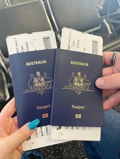 two people holding up their australian passport in front of the seats on an airport plane