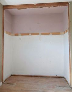 an empty room with unfinished walls and wood flooring