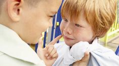 a young boy is talking to an older boy who is wearing a white shirt and tie