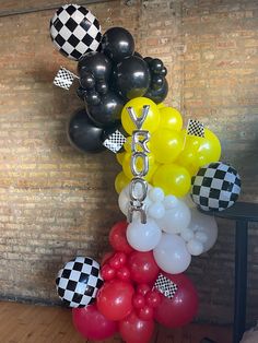 some balloons are hanging on the wall and black and white checkered paper is in the air