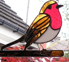 a stained glass bird hanging from the side of a building