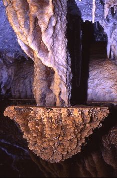 the inside of a cave with water and rock formations on it's sides, as seen from below