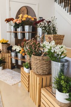 several baskets filled with flowers sitting on top of a counter next to a stair case