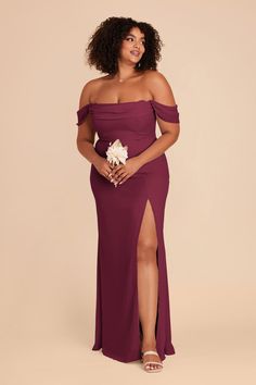 a woman in a long purple dress posing for the camera