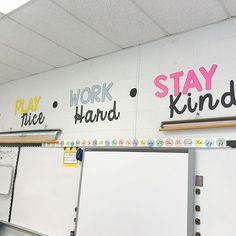 a classroom with whiteboard and writing on the wall that says work hard, stay kind