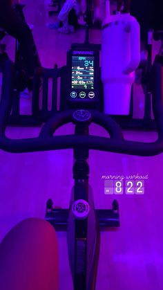 there is a cell phone on the handlebars of a bike in purple light