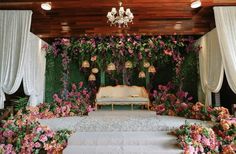 an outdoor ceremony setup with flowers and chandelier