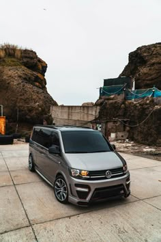 a grey van parked in front of some rocks