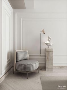 a white room with a chair, lamp and vase on the floor in front of it