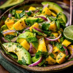 a salad with mango, avocado and cilantro in a brown bowl