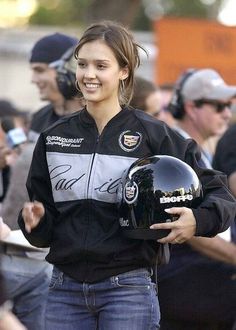 a woman holding a motorcycle helmet and smiling