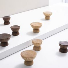 several wooden knobs are lined up on a white surface