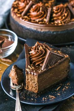 a slice of chocolate cake on a blue plate with a fork next to the pie