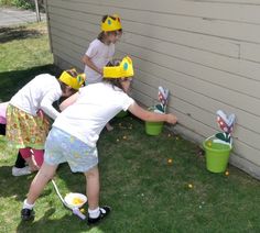 three children are playing with buckets in the yard