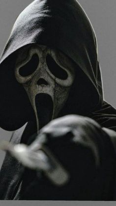 a person wearing a hooded costume and holding something in their hand with his mouth open