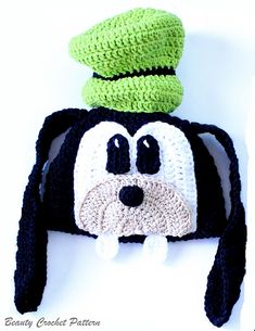 a crocheted hat with a dog's face on it and a green top