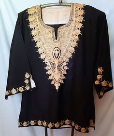 This is a very pretty runic top with an intricate thread embellishment around the neck and bodice and hem.  Armpit to armpit is 21 inches.  Sale is final. Traditional Gold V-neck Tops, Fitted Gold Cotton Top, Traditional Fitted V-neck Tunic, Fitted Gold Embellished Kurta, Fitted Gold Top For Festivals, Bohemian Fitted Kurta For Ceremonies, Fitted Bohemian Kurta For Ceremonial Occasions, Festive Tunic Top With Embroidered Neckline, Fitted Tops With Embroidered Neckline For Festive Occasions