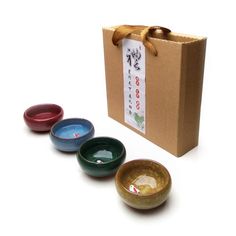 three small bowls are sitting in front of a box