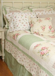 a white bed topped with lots of pillows next to a night stand and nightstands