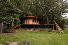 a wooden house sitting on top of a lush green field