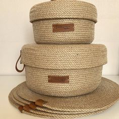 three woven baskets stacked on top of each other with leather tags attached to the lids