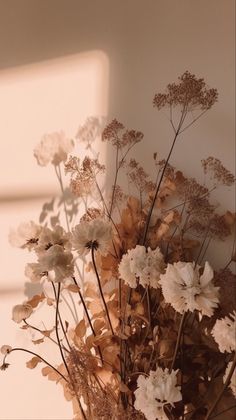 a vase filled with lots of flowers on top of a table