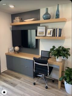 a desk with a laptop computer on top of it next to a wall mounted tv