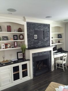 a living room filled with furniture and a fire place under a tv mounted on a wall