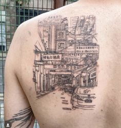 the back of a man's shoulder with a cityscape tattoo on it