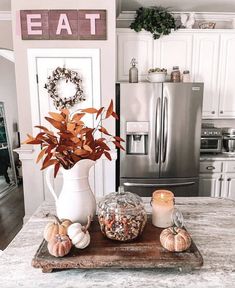 a kitchen table topped with a white vase filled with flowers