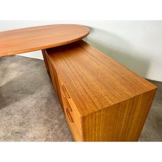 an oval shaped wooden table with two drawers