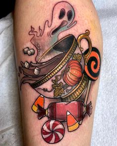 a tattoo on the leg of a person with candy and candies in front of them