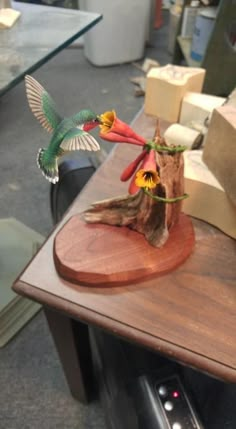 a wooden table topped with a bird sculpture