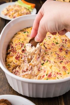 a person dipping something into a casserole dish